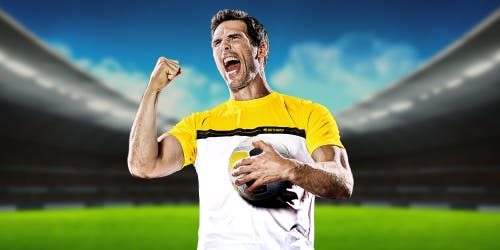 Jugador de fútbol con camiseta amarilla celebrando en el estadio